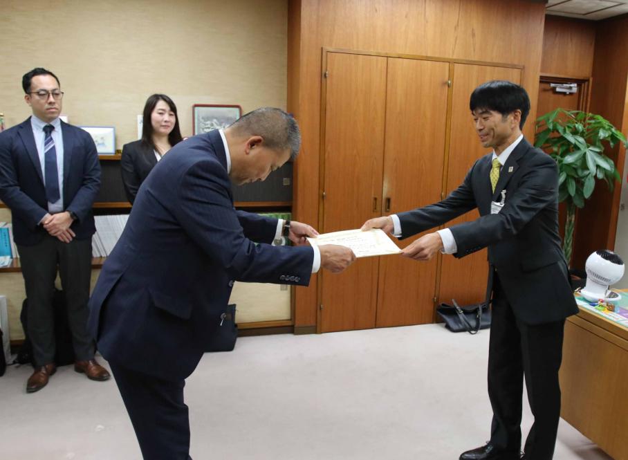 副区長室で齊藤支社長に感謝状を贈呈する武越副区長。後ろには北浦氏と鈴木氏が控える。