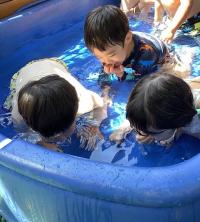 2歳児プールの水に顔をつけている