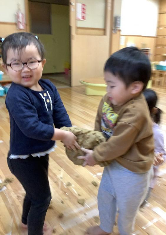 2さいじくらすがつちねんどにふれているようす