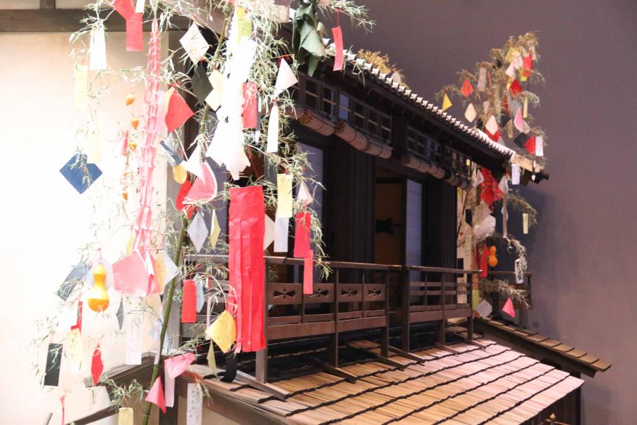 赤や黄色、青などの色紙や吹流しが結びつけられた笹が左右に飾られている江戸のお店