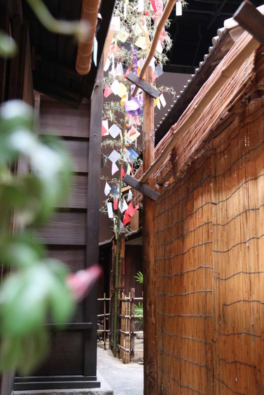 江戸の民家の軒先に飾られた竹。手前には朝顔の造花。