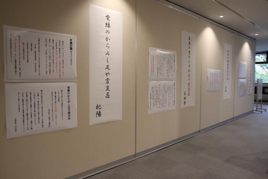 京極や久保田などの震災にまつわる俳句3点が大きく印刷され、壁に貼られている。隣には俳人、句を解説するパネルも掲示。