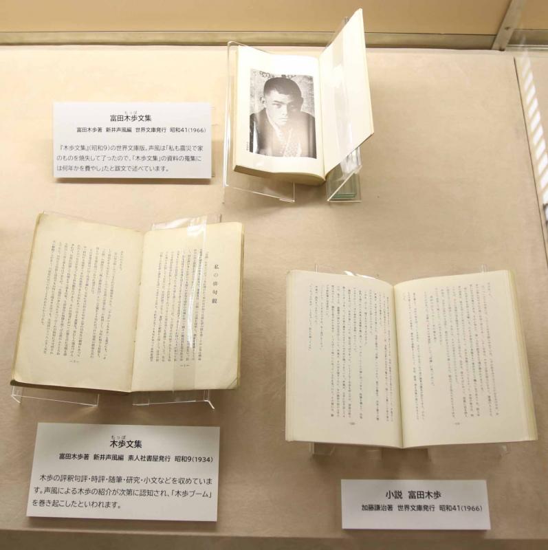 ショーケースに陳列された富田の句集や文集3点の写真。文集の1ページ目には富田の顔写真が白黒で印刷されている。