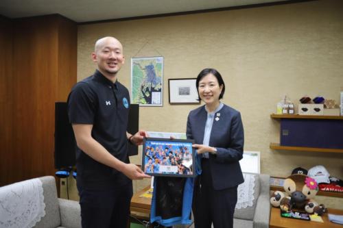 サイン入りの写真を持つ区長