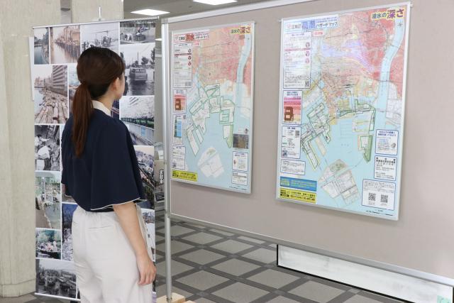 「まちの記憶と未来展」の展示ポスターを見学している女性